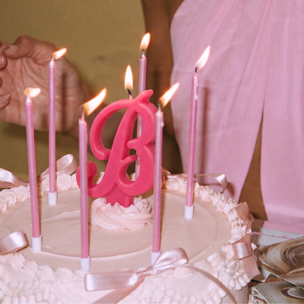 Roze Boozyshop-logo met een verjaardagstaart met kaarsjes, ballonnen en confetti voor Boozyshop Birthday